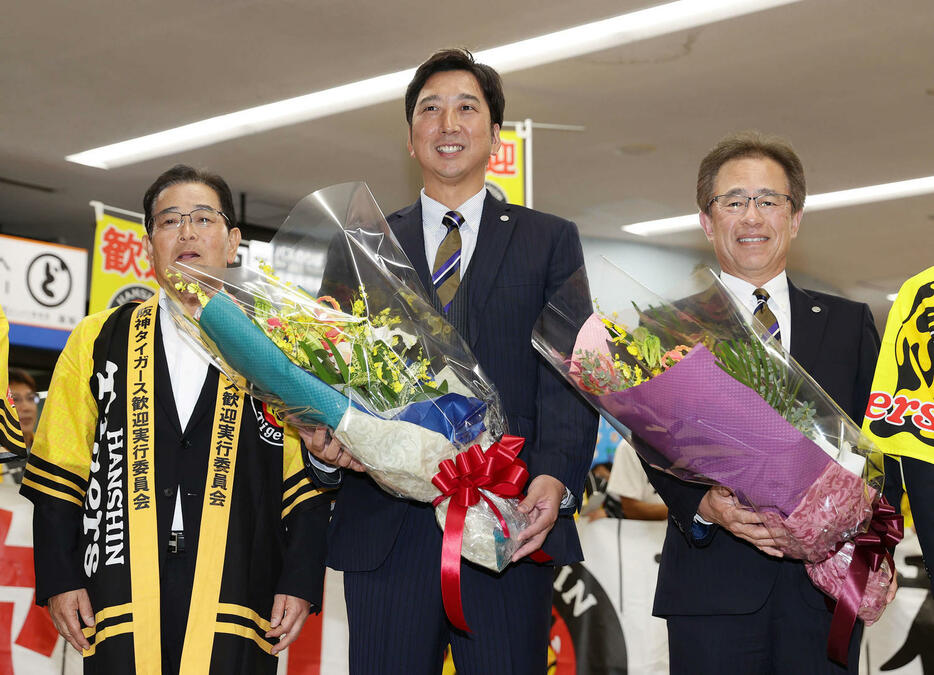 高知龍馬空港に到着した阪神藤川監督（中央）は歓迎セレモニーで花束を受け取る。左は横山安芸市長、右は阪神粟井球団社長（撮影・前田充）