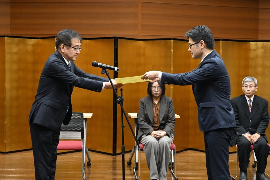 根本局長（左）から賞状を受け取る水城孝敬さん