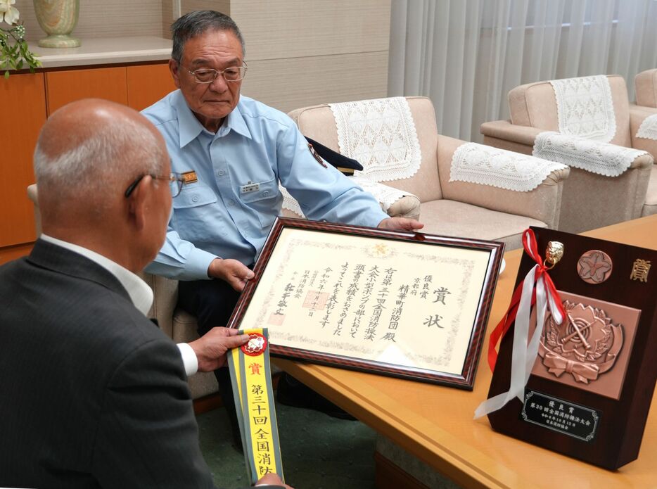 杉浦町長（左）に全国大会の賞状を見せる喜多消防団長＝京都府精華町役場