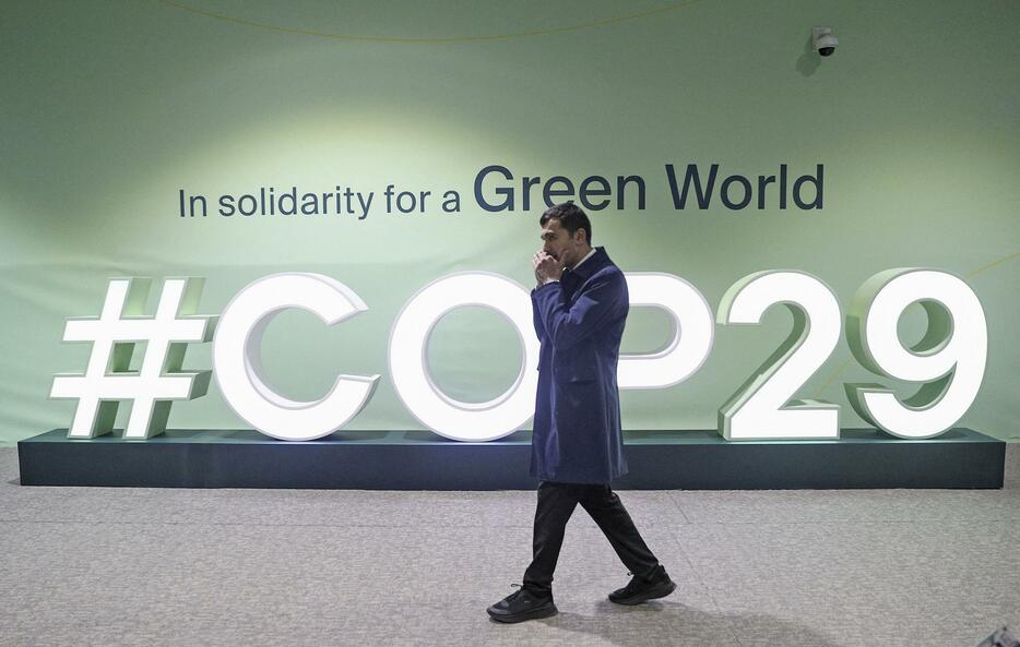 COP29の会場を歩く男性＝8日、アゼルバイジャン・バクー（ロイター＝共同）