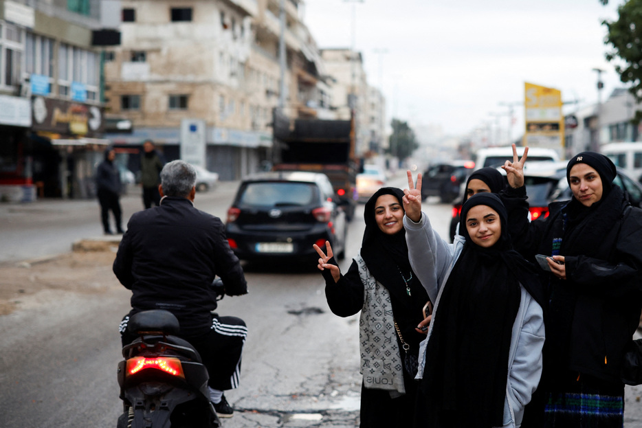 　１１月２７日、イスラエルとイラン支援下にあるレバノンの武装組織ヒズボラの戦闘を巡るイスラエルとレバノンの停戦合意が、現地時間２７日午前４時（日本時間同１１時）に発効した。写真は、停戦発効後レバノンのティルスに戻ってくる人々を歓迎する女性たち。２７日撮影（２０２４年　ロイター/Adnan Abidi）