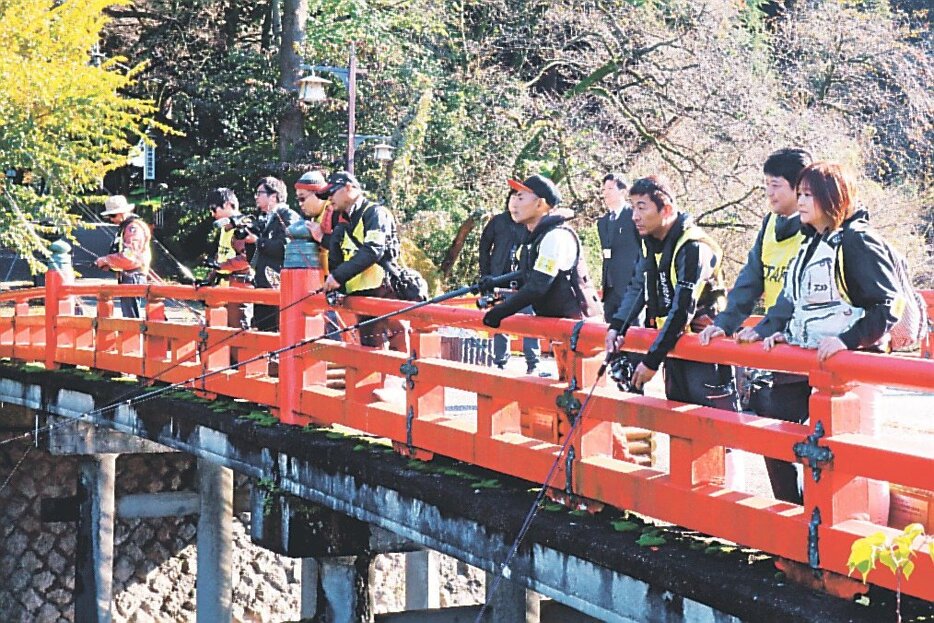 アリゲーターガーを釣ろうと、さおを伸ばす参加者＝高岡市古城