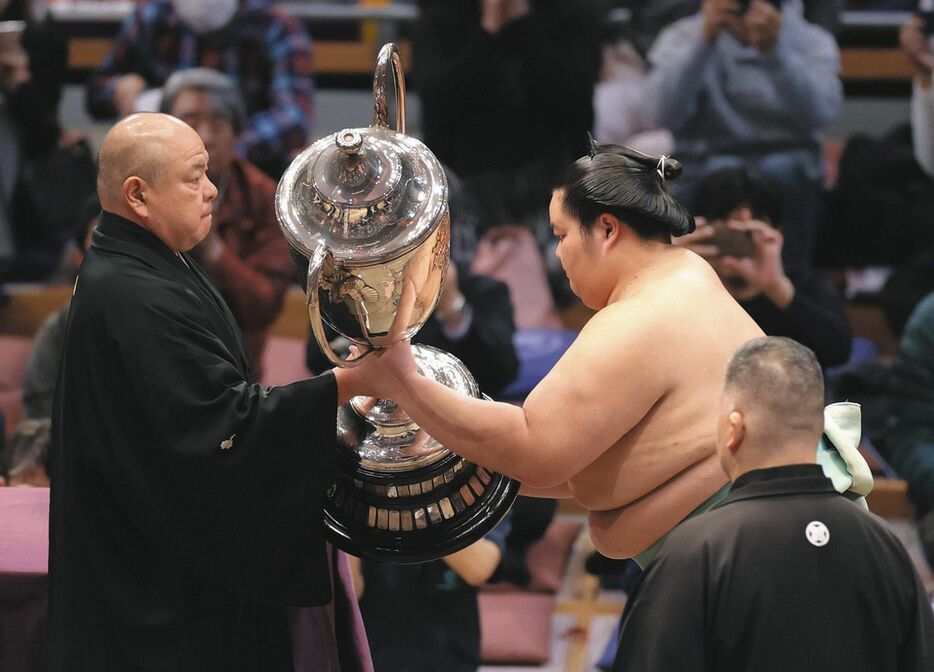 大相撲九州場所で優勝し、表彰式で賜杯を受け取る琴桜（右）