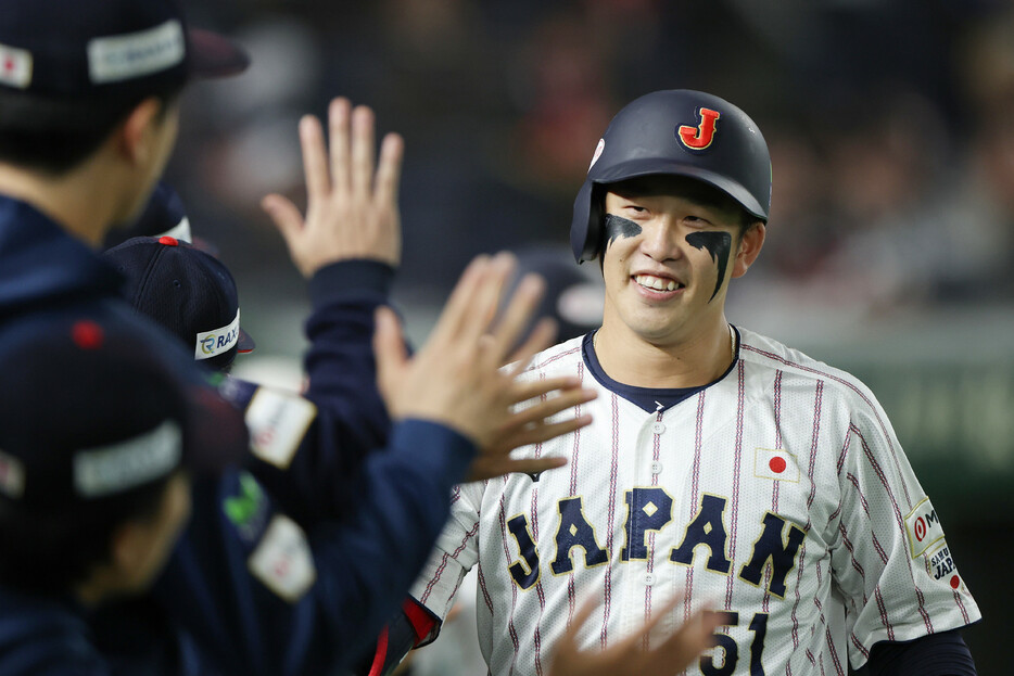 米国戦の８回、２点本塁打を放ち、ベンチ前で祝福される日本代表の小園＝２１日、東京ドーム