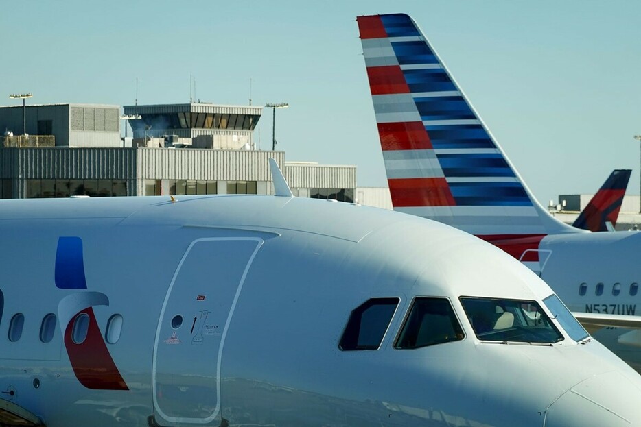 アメリカン航空機内で飛行中に乗客がドアを開けようとし拘束された