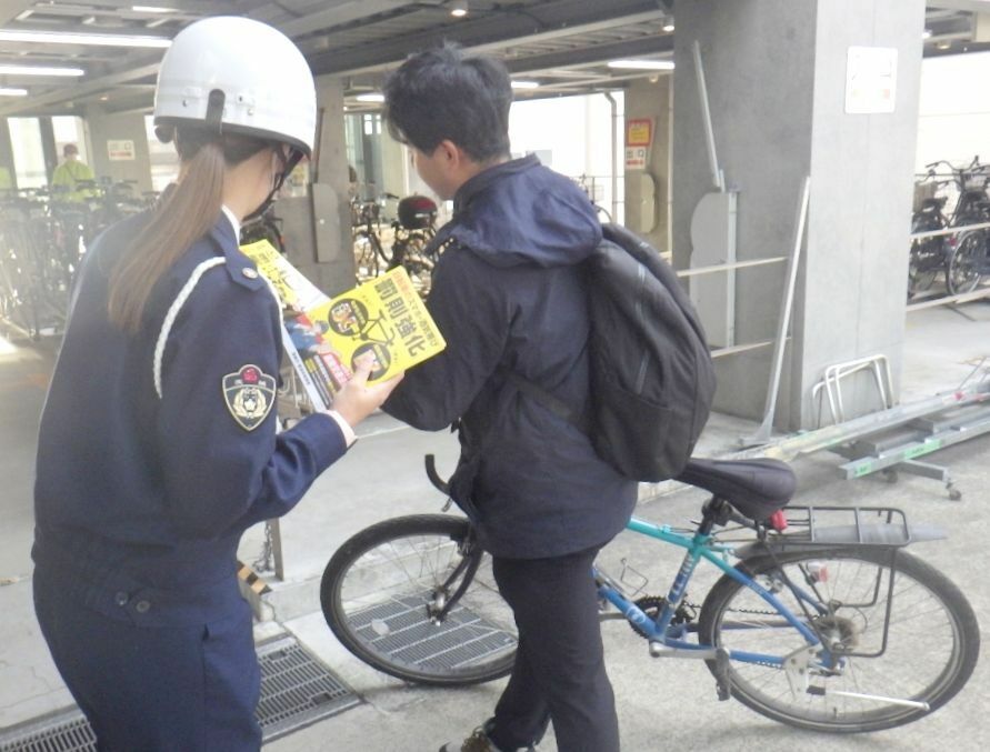 自転車利用者に新たに罰則となった「ながら運転」について周知する捜査員=取手市内