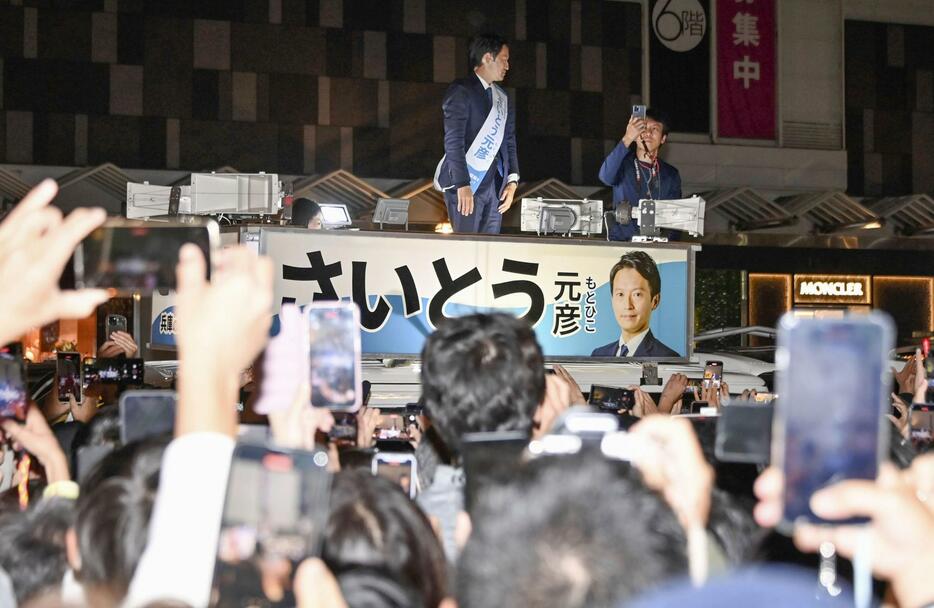 兵庫県知事選の選挙戦最終日、スマートフォンを掲げる大勢の有権者の前で街頭演説する斎藤元彦氏＝16日、神戸市