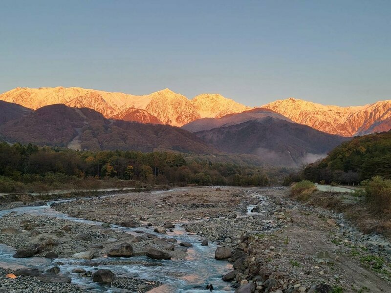 朝焼けに染まる雪山と紅葉という贅沢な絶景