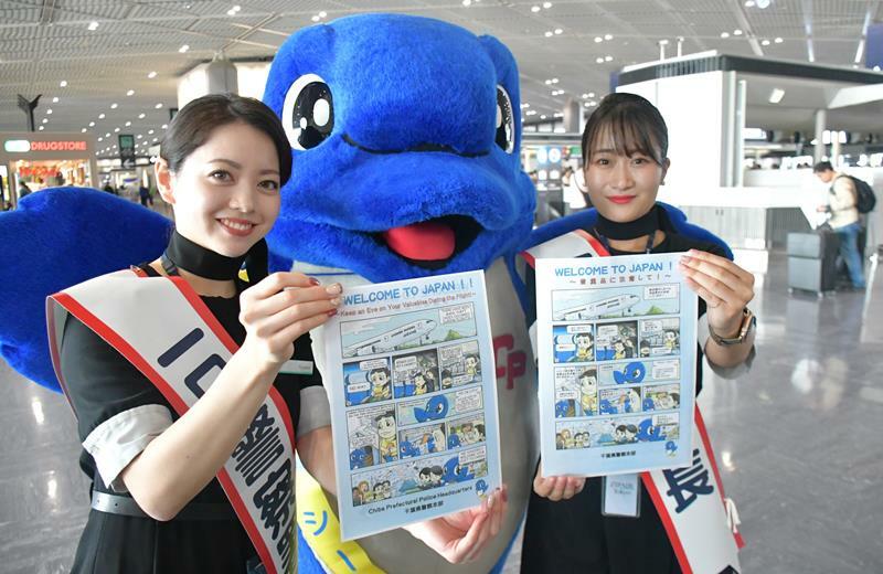 航空機内での窃盗被害防止に向けた注意喚起の漫画を紹介する一日警察署長の客室乗務員ら＝22日、成田市の成田空港