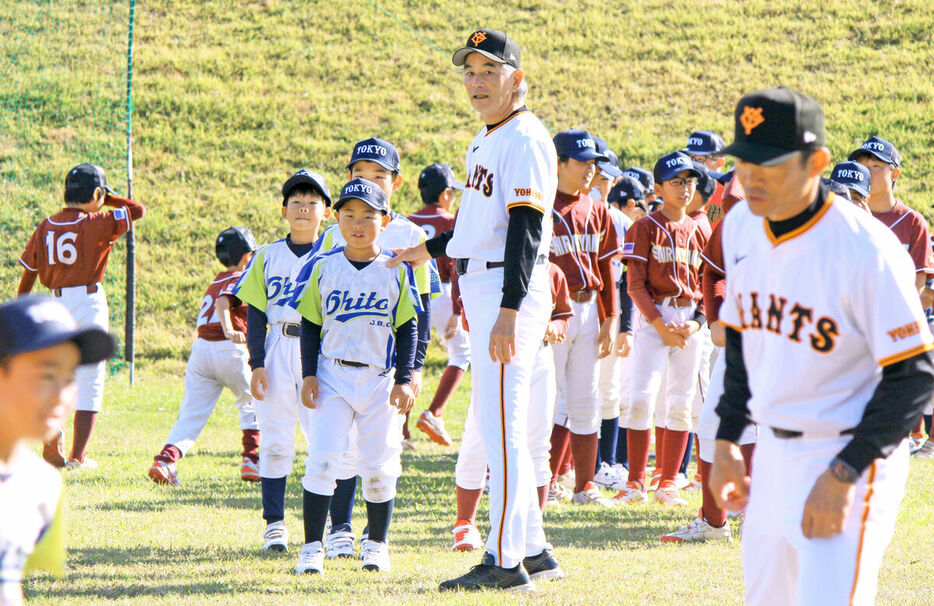 伊豆の国市で地元の小学生選手に走塁を指導する巨人OBの定岡氏（中央）と仁志氏（右手前）