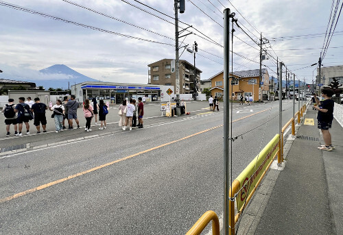 富士山撮影スポットのコンビニ店前。店と反対側の歩道沿い（右側）には防護柵が設置されていたが、店前には設置されていなかった（８月、山梨県富士河口湖町で）