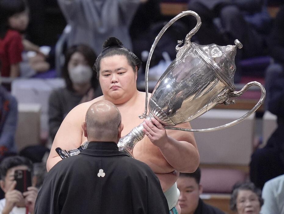 大相撲九州場所で初優勝を果たし、日本相撲協会の八角理事長（手前）から賜杯を受け取る琴桜＝24日、福岡市の福岡国際センター