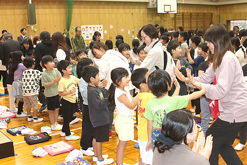 児童がハイタッチで地域の人たちを見送った