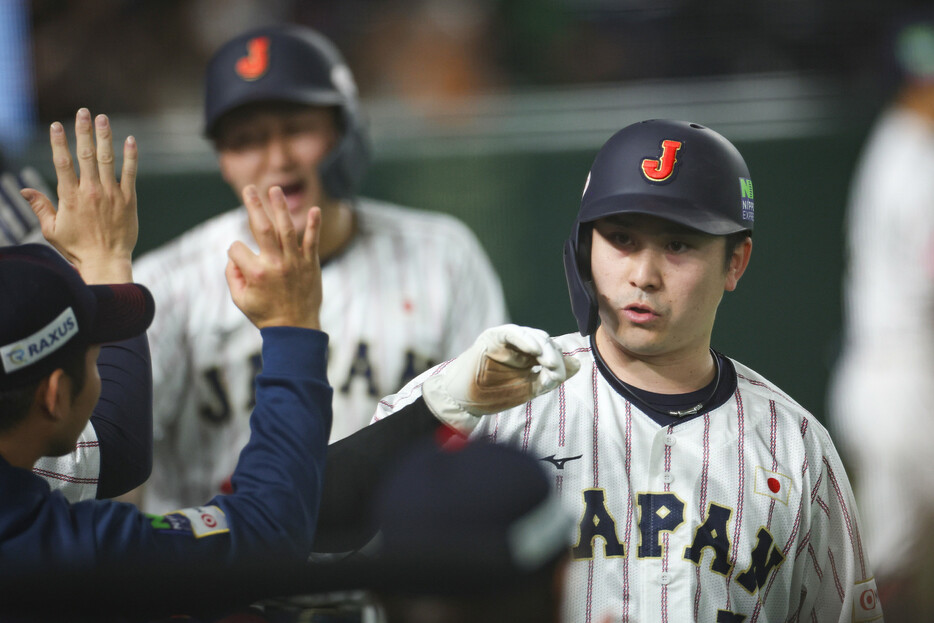 台湾戦の５回、清宮の三塁打で生還し、祝福される日本代表の三塁走者・佐野（右）ら＝２３日、東京ドーム