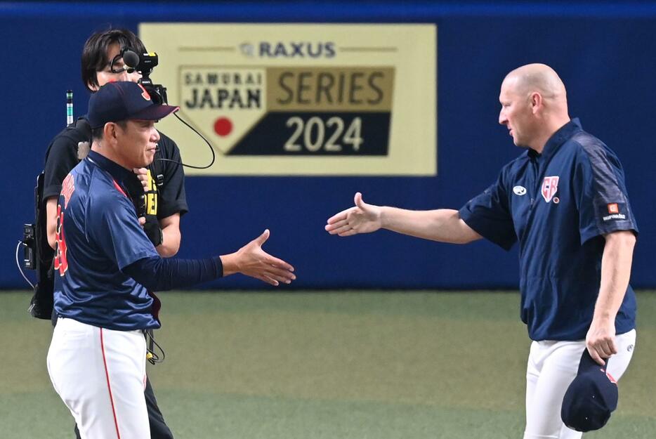 　試合後、握手を交わす（左から）井端監督とハジム監督（撮影・飯室逸平）