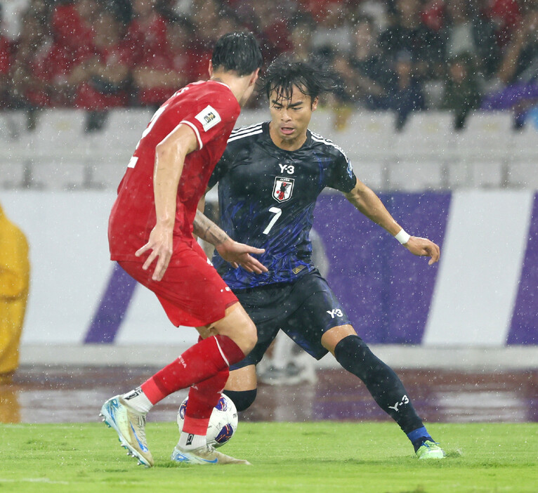 サッカーＷ杯予選。インドネシア戦の前半、競り合う三笘（右）＝１５日、ジャカルタ