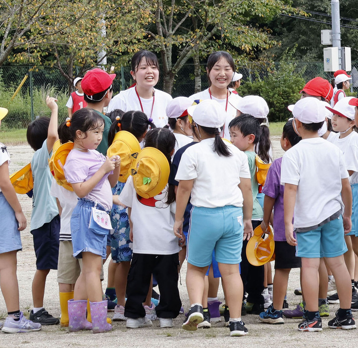 茨城県笠間市立大原小の校庭で、児童と遊ぶ新井菜生さん（奥左）、大島胡桃さん（同右）＝2024年9月、茨城県笠間市