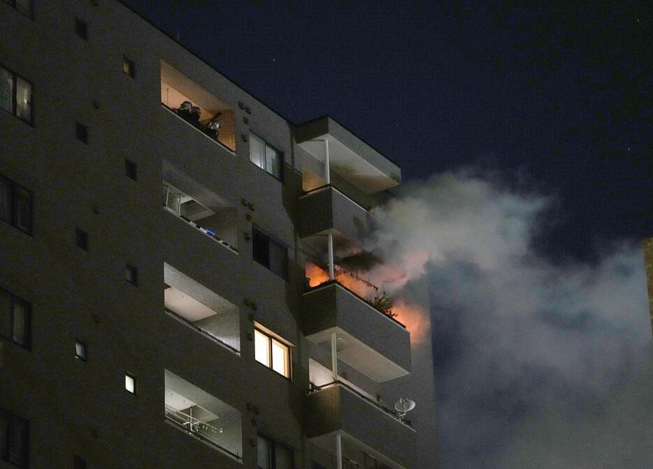 炎が上がる川崎市川崎区のマンション＝27日午後10時25分