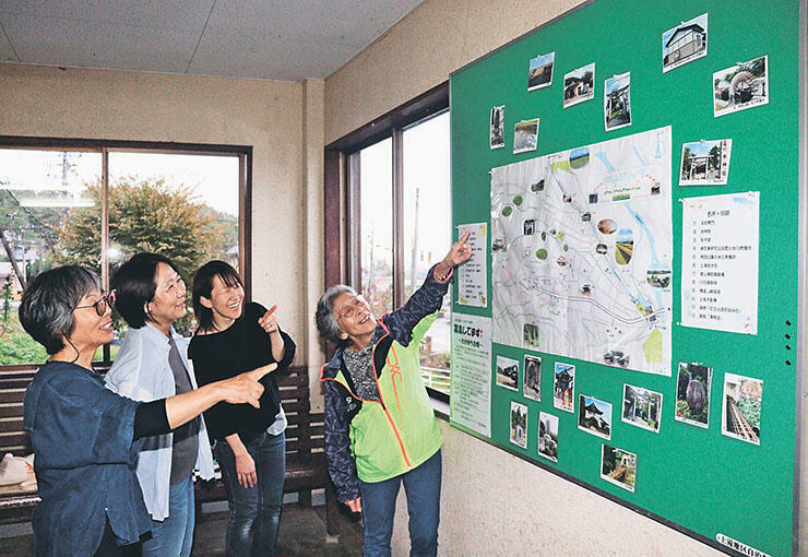 大川寺駅に掲示した手作りの地図を紹介する駅ガールズのメンバー