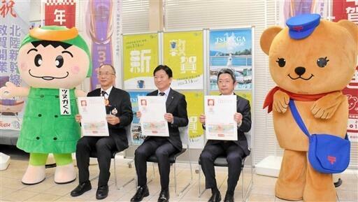 敦賀市オリジナルの年賀はがきの見本を持つ米澤市長（中央）ら=11月1日、福井県敦賀市の敦賀郵便局