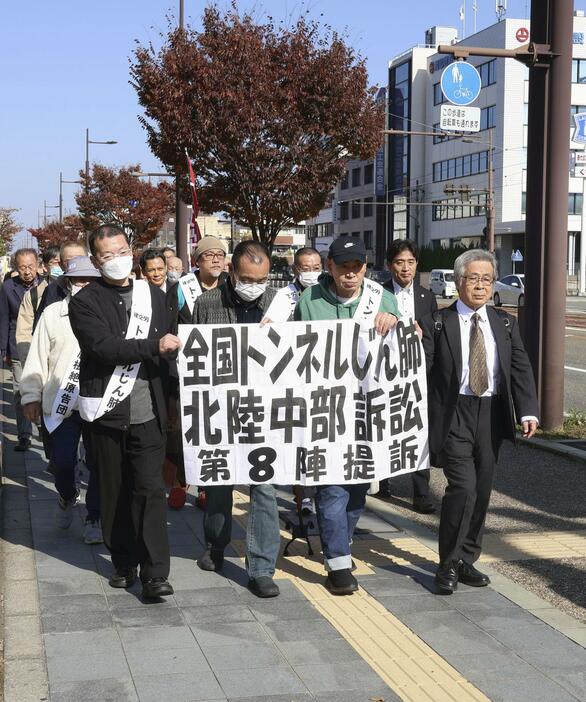 提訴のため福井地裁に向かう原告団ら＝14日午前、福井市