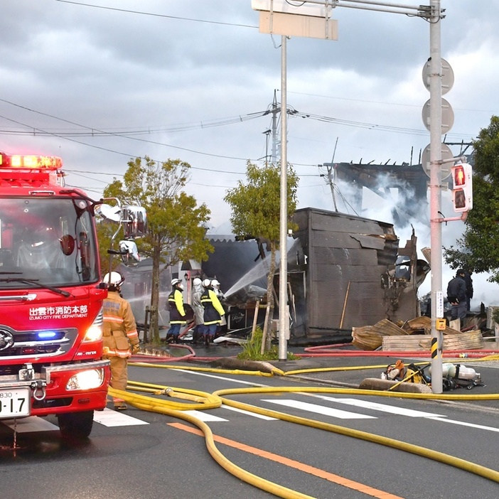 消火活動を行う出雲市消防本部の隊員ら＝３０日午前７時１２分、出雲市平田町