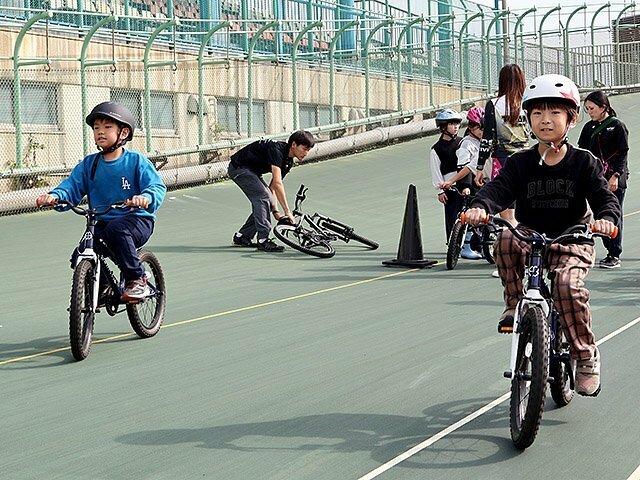 自転車でバンクを走る児童