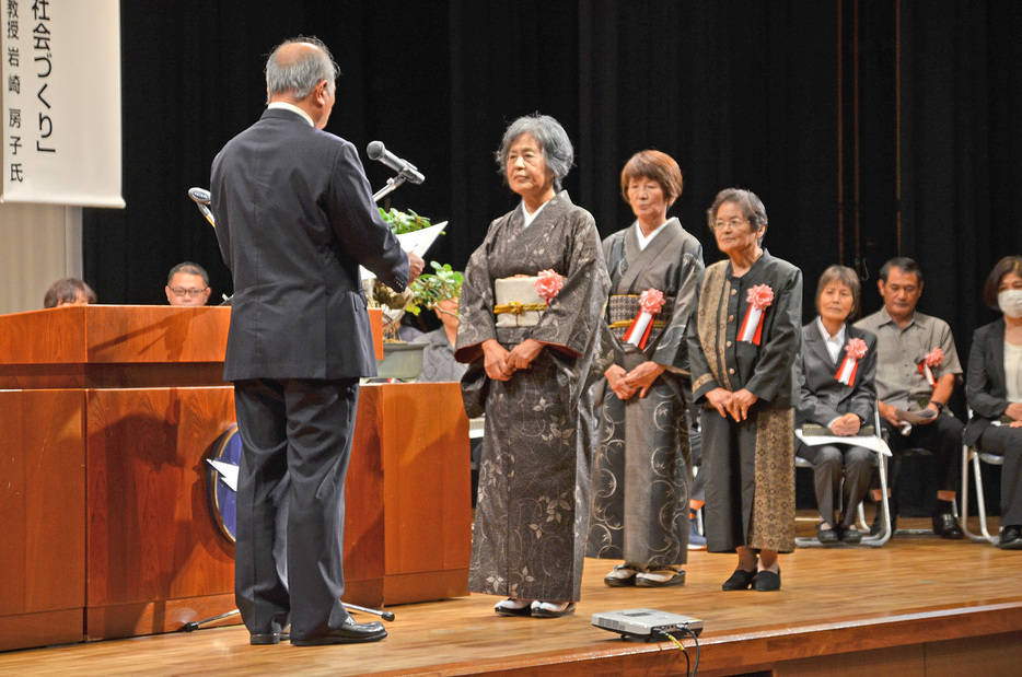 表彰状を受け取る社会福祉功労者＝15日、鹿児島県龍郷町