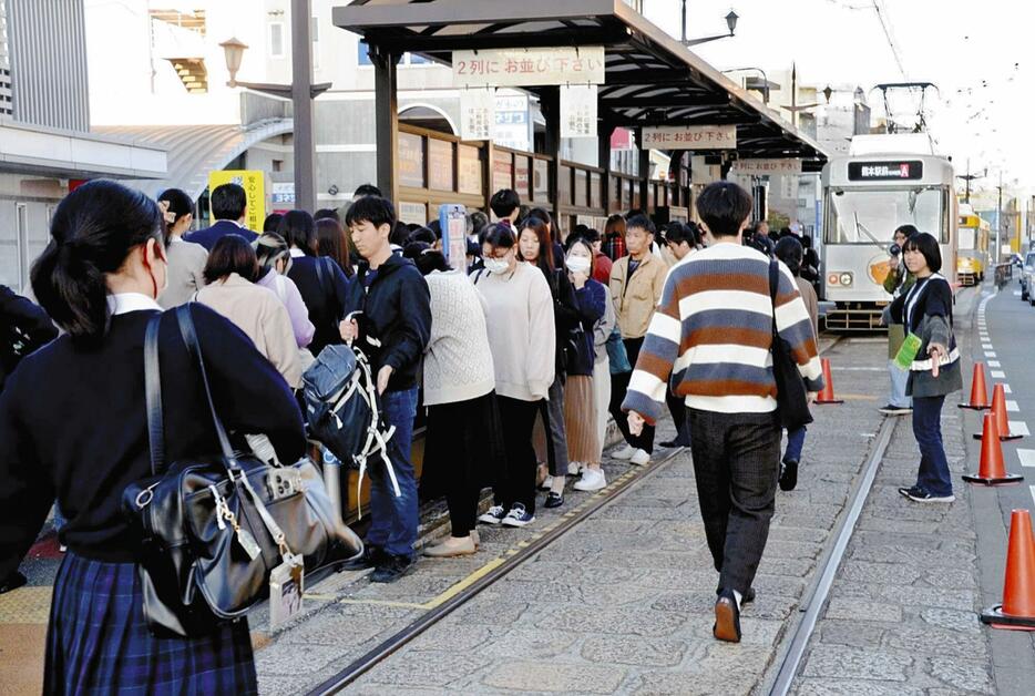 乗り場に入りきれずに軌道上に利用者があふれる健軍町電停