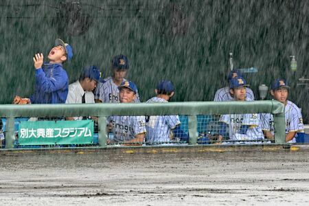 雨で試合開始が遅れ、ベンチで待機するエナジックの選手たち＝１日午前１０時４６分、大分市・別大興産スタジアム