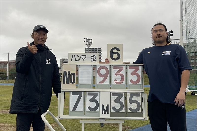 自己新を投げた中川が疋田晃久コーチとツースショット（九州共立大提供）