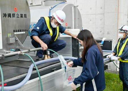 県企業局の給水車から飲料用水をもらう県立辺土名高校の生徒＝１１日午後６時ごろ、大宜味村饒波・同校（比嘉海人撮影）