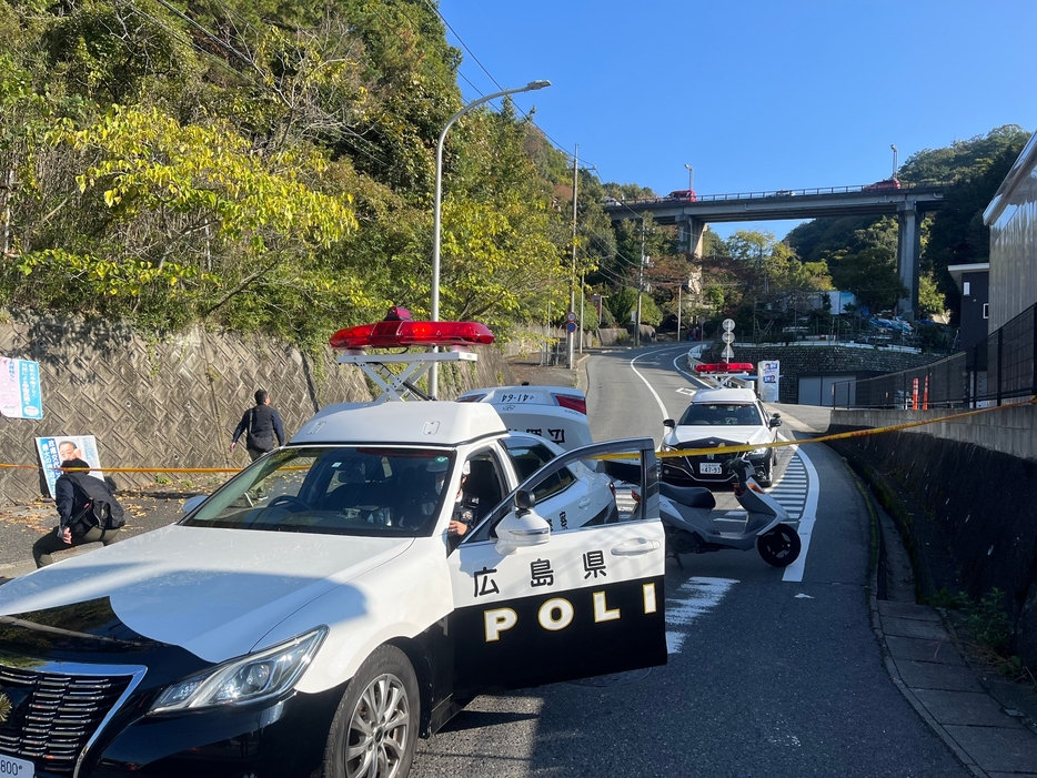 ダンプカーと乗用車が転落した現場の周辺に駆け付けた警察車両（12日午前9時47分）