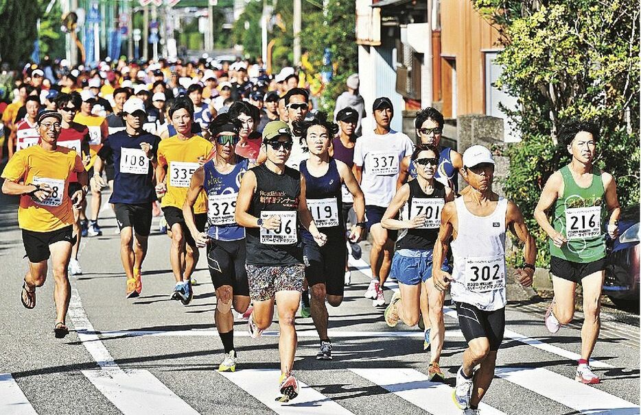 南紀日置川リバーサイドマラソンで勢いよくスタートするハーフマラソンの参加者（１０日、白浜町日置で）