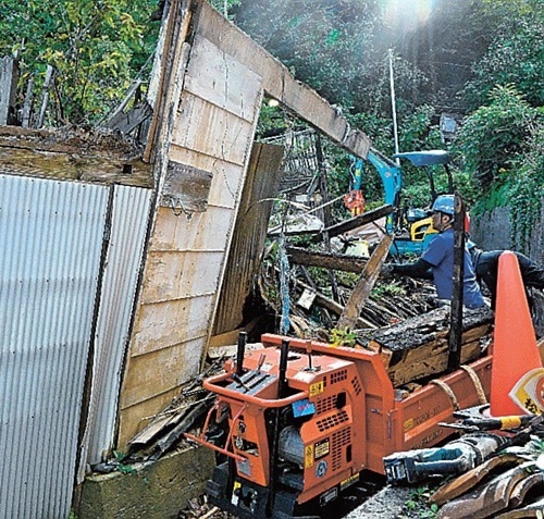 崩壊した特定空き家の解体を進める作業員＝松江市美保関町七類