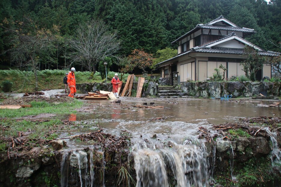 裏山から流れる川があふれ、土砂と水が民家の庭を浸した（２日午後３時１０分・南丹市園部町埴生）