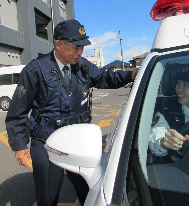 穏やかなまなざしで若手警官を指導する溝川泰警部補＝滋賀県草津市