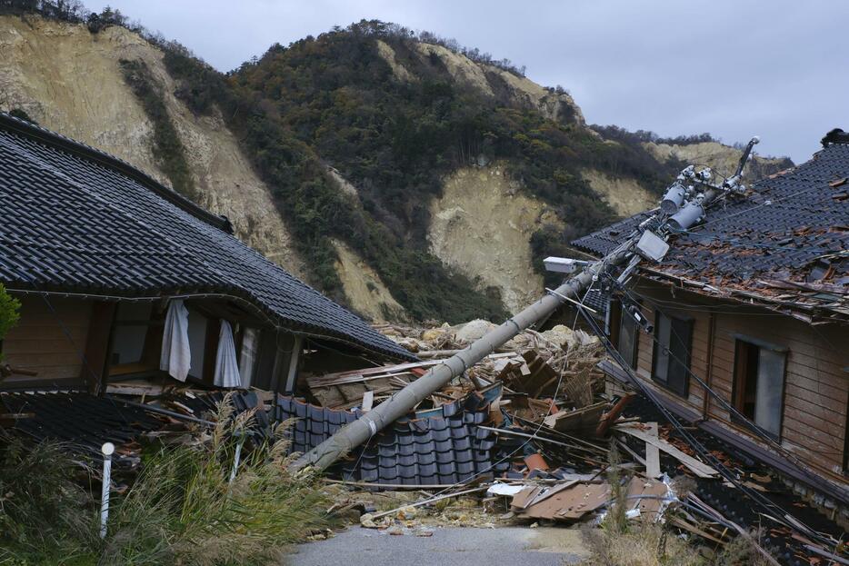 豪雨による土砂に埋もれた石川県珠洲市仁江町の家屋＝20日午後