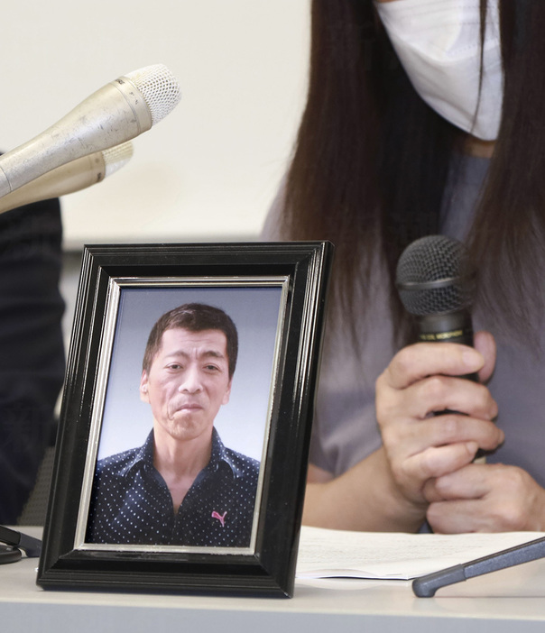 事故で亡くなった小柳さんの遺影を前に記者会見する遺族