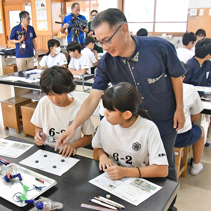 小山教授（中央）からアドバイスを受ける児童ら（6日、奄美市の名瀬小学校）