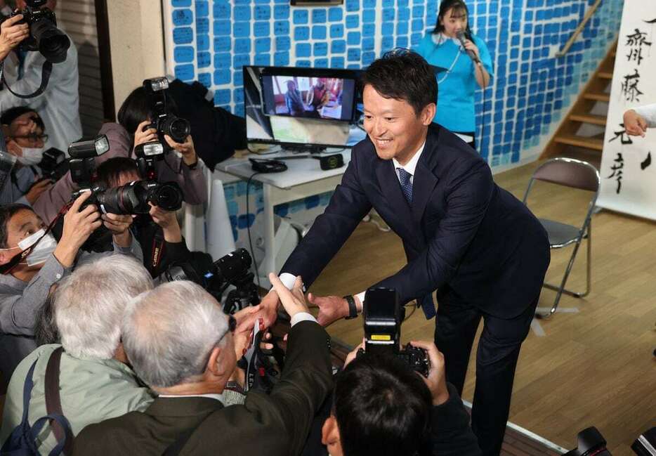 再選が確実となり支援者と握手する前知事の斎藤元彦氏＝17日午後9時45分、神戸市中央区（彦野公太朗撮影）