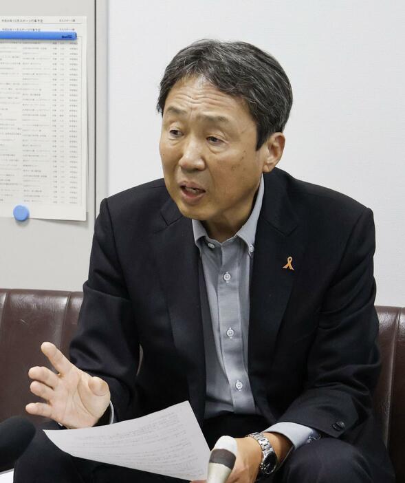 記者会見する市民団体の久米慶典事務局長＝13日午後、山口県岩国市