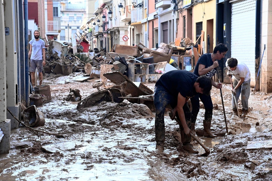 洪水に見舞われたスペイン東部バレンシア自治州で、泥に覆われた道路を掃除する人々（2024年10月31日撮影）。【翻訳編集】 AFPBB News