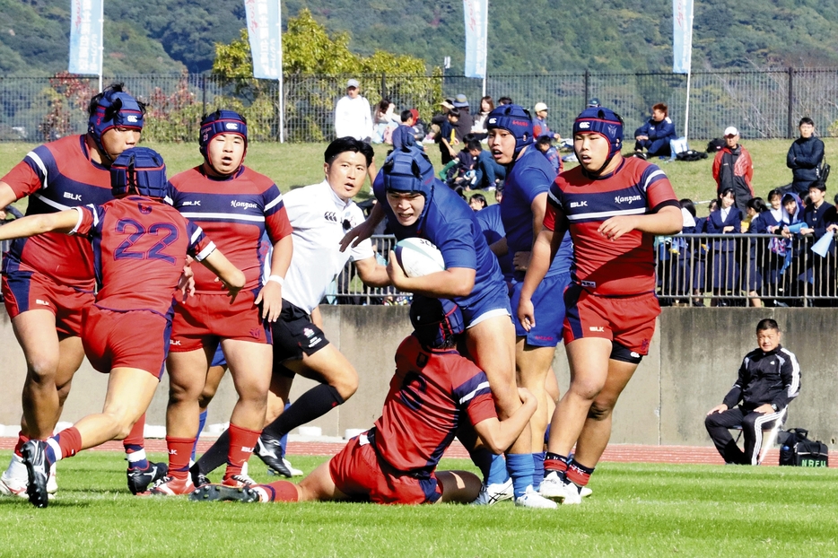 激しくボールを奪い合う長崎北陽台（青色のユニホーム）と長崎南山の選手たち