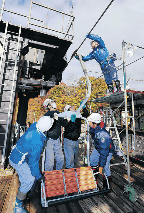 2人乗りのリフトをケーブルに取り付ける作業員=金沢市営医王山スキー場