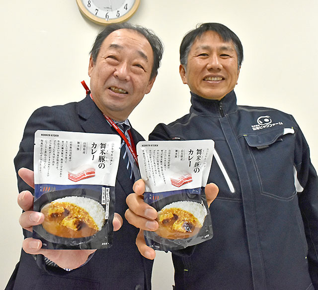 山辺町特産「舞米豚」を使ったカレーをＰＲする沼尻明男局長（左）と阿部秀顕社長＝山辺郵便局