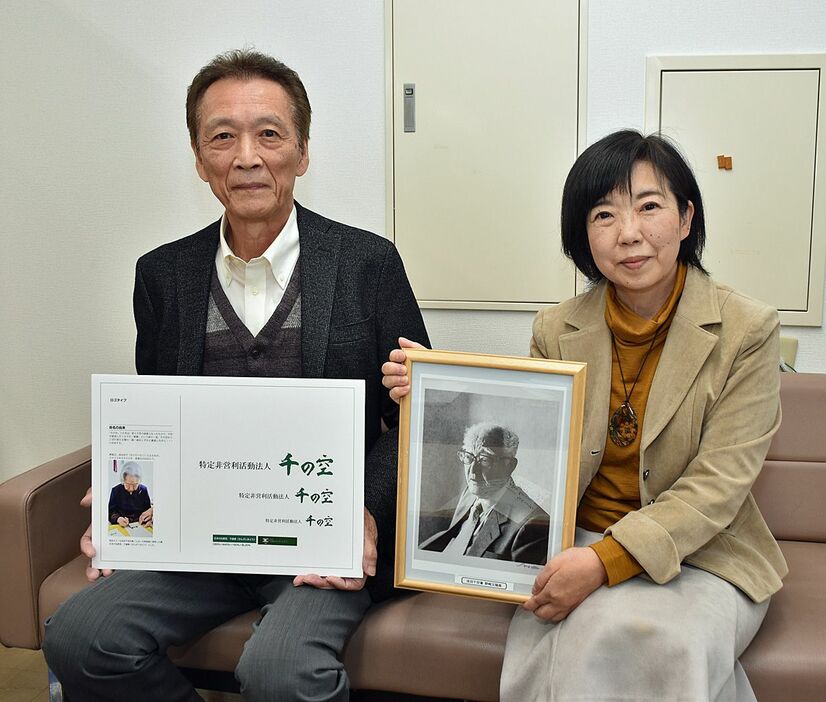 成田千空氏の肖像画を手にするNPO法人「千の空」の齋藤代表（右）と木村副代表