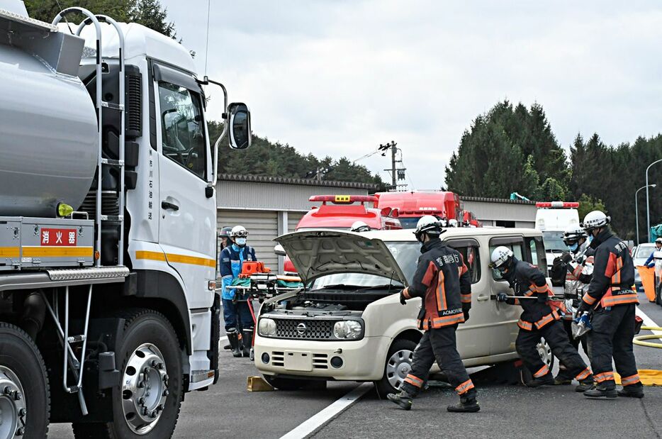 訓練で、事故車両に取り残された運転手の救出に臨む消防職員ら＝8日、青森市