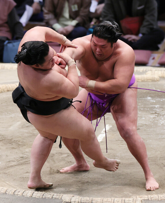 大相撲九州場所１０日目。尊富士（右）は明生を押し倒しで破り、勝ち越しを決める＝１９日、福岡国際センター