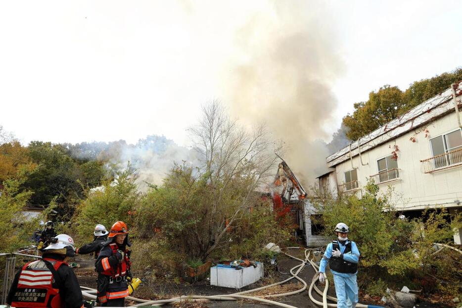 白煙をあげて燃える建物＝２７日午前、加古川市神野町西之山